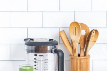 Mixer avec verre de boisson verte à côté et rangement vaisselle