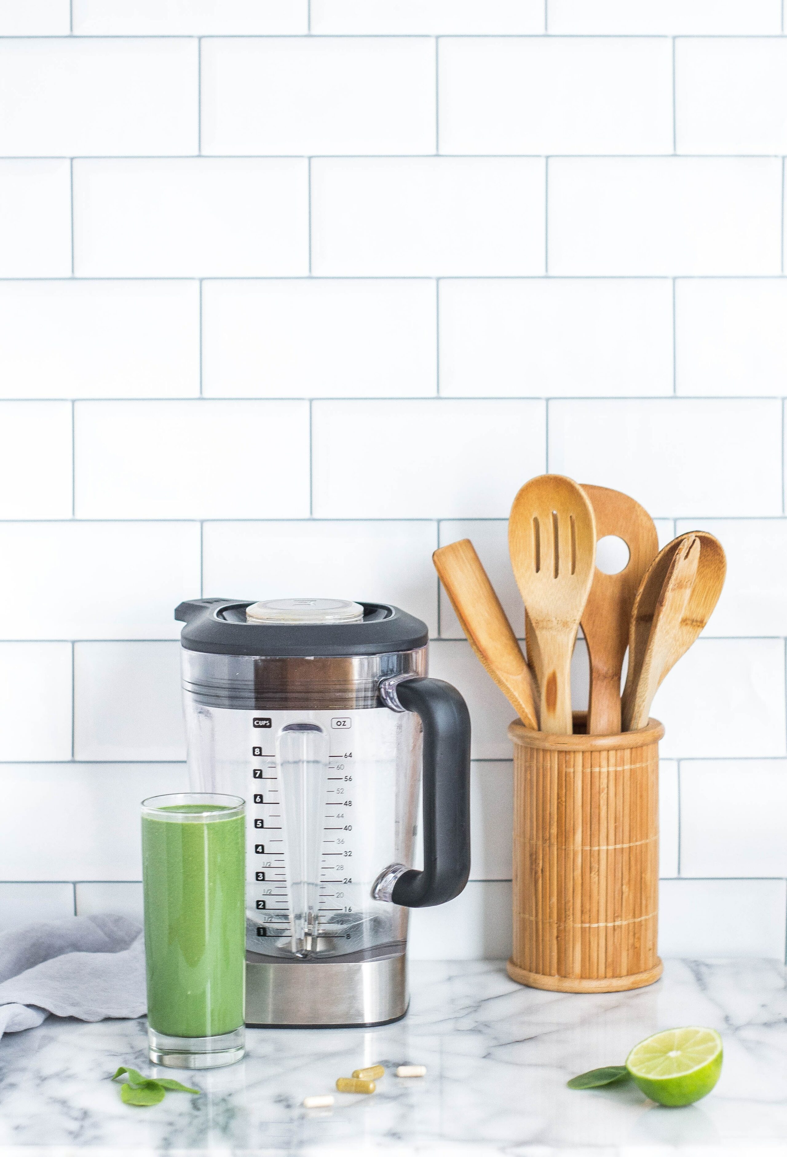 Mixer avec verre de boisson verte à côté et rangement vaisselle